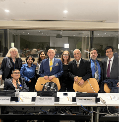 Group of delegates posing together in a conference meeting room.