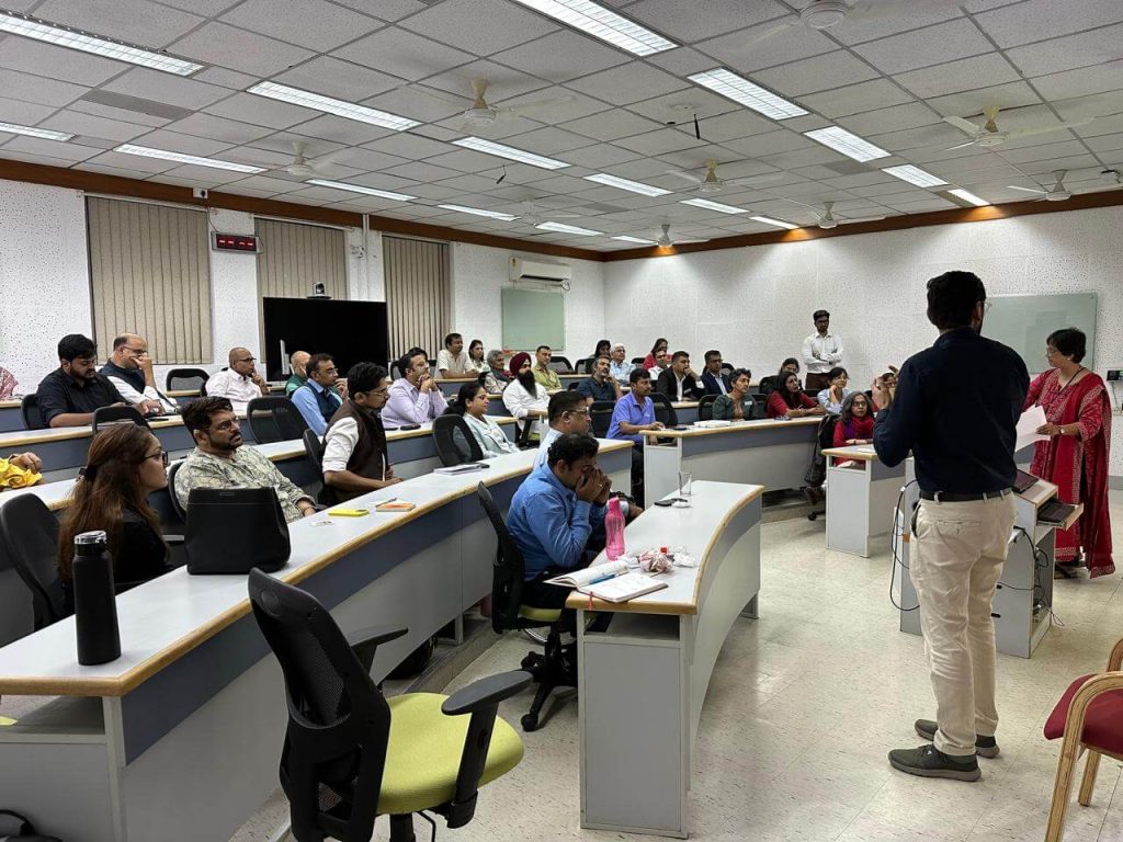 A speaker presenting to an audience in a classroom setting.