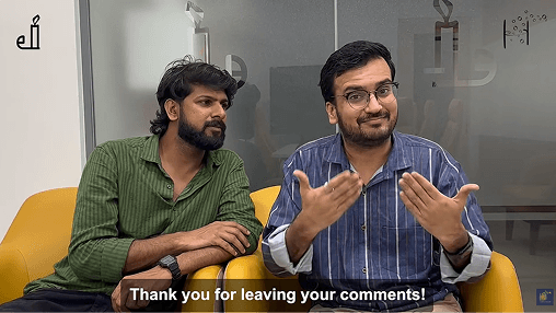 Two people sit on a couch, with one using sign language